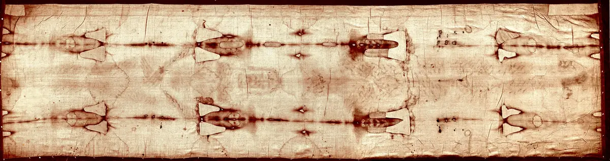 The whole Shroud as a photographic negative, horizontal: frontal and dorsal images head to head, with the burn marks and patches of 1532.