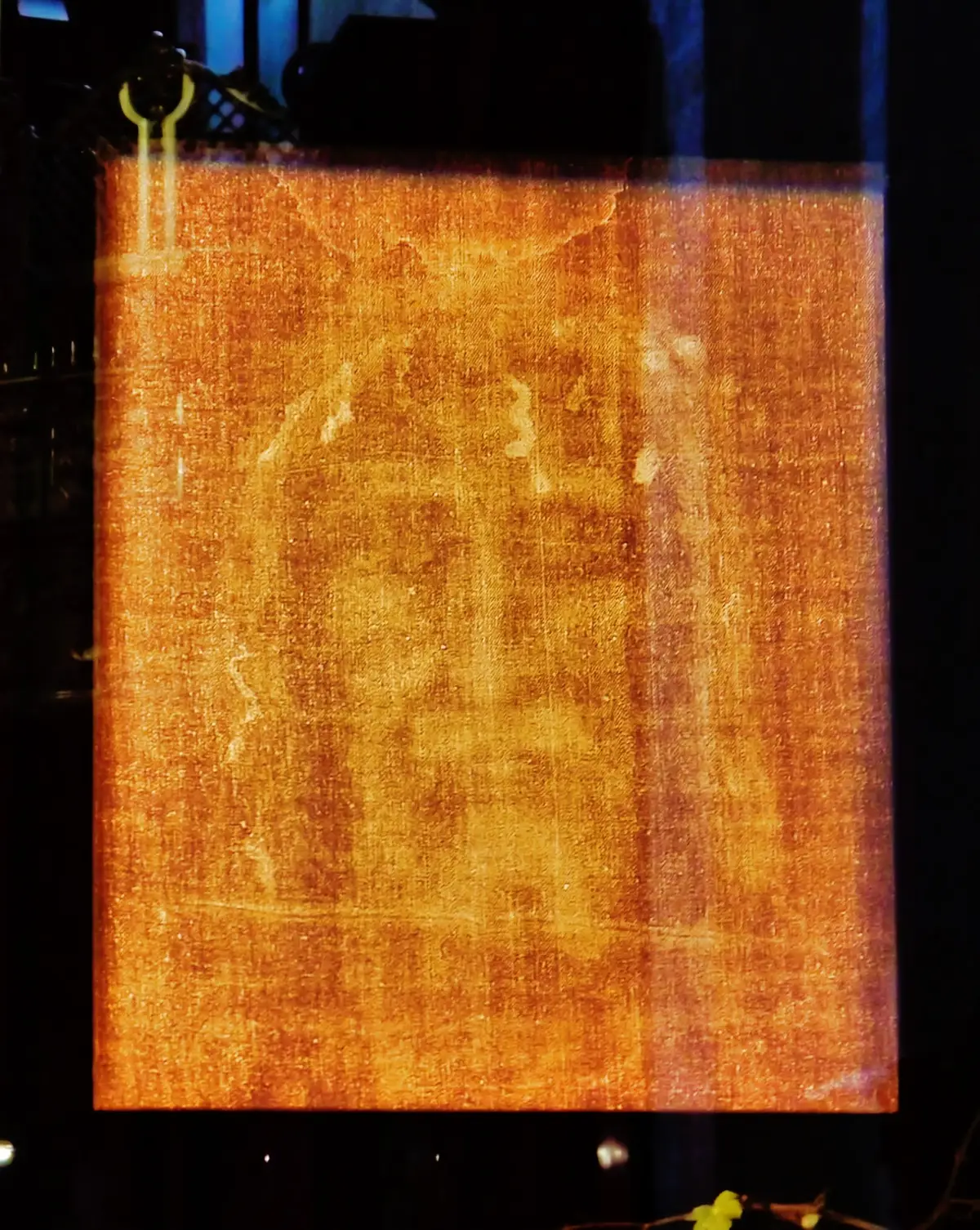 The Shroud’s sealed case in the cathedral, a long low box under a photographic copy of the cloth.