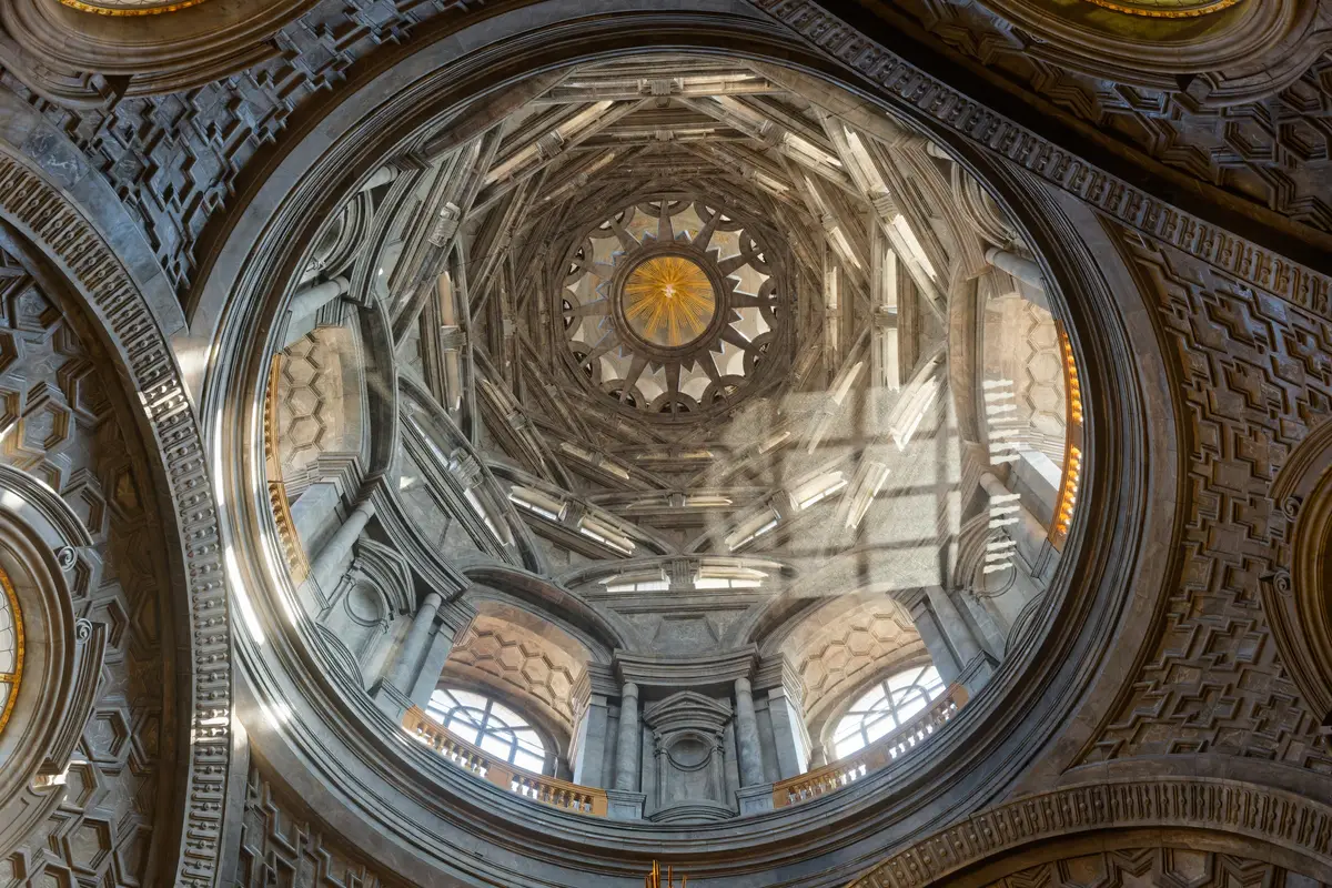 Looking up into the restored dome of the Guarini chapel: tiers of stacked arches rising to a star.
